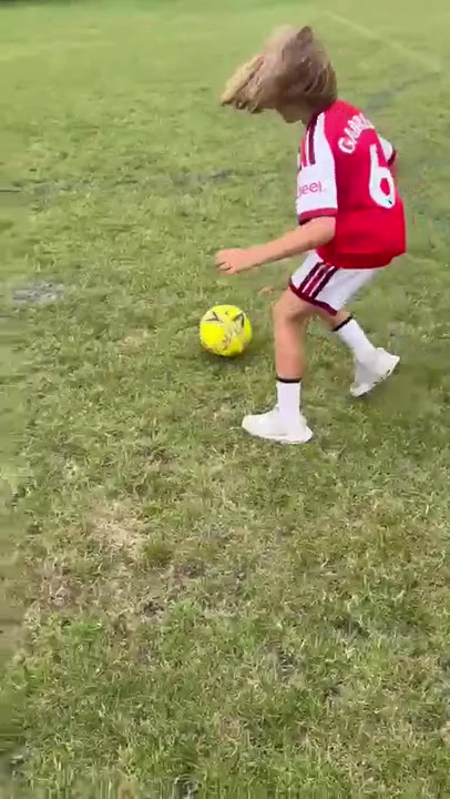 A young player practising dribbling